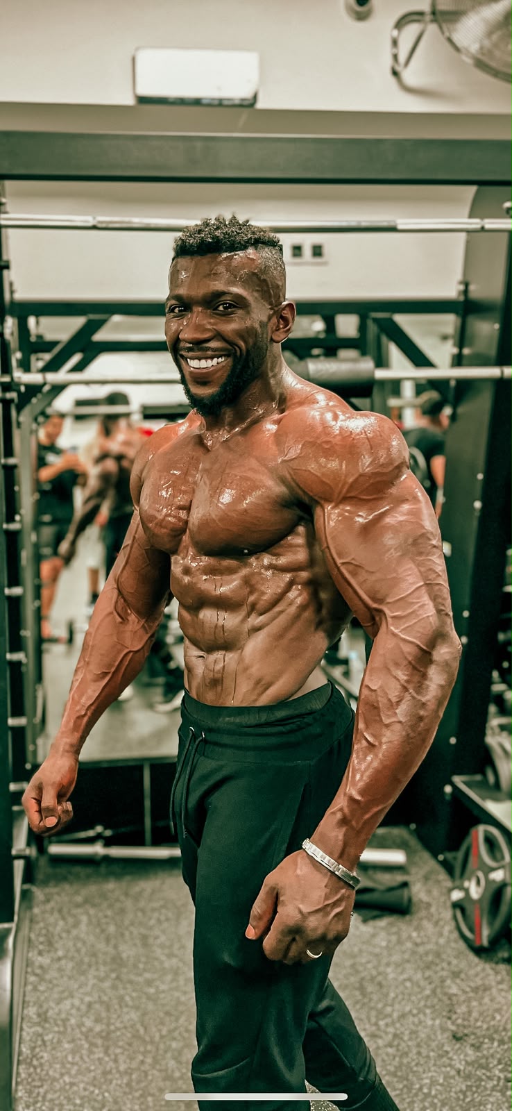 Soufiane Ballouk souriant dans une salle de sport, torse musclé